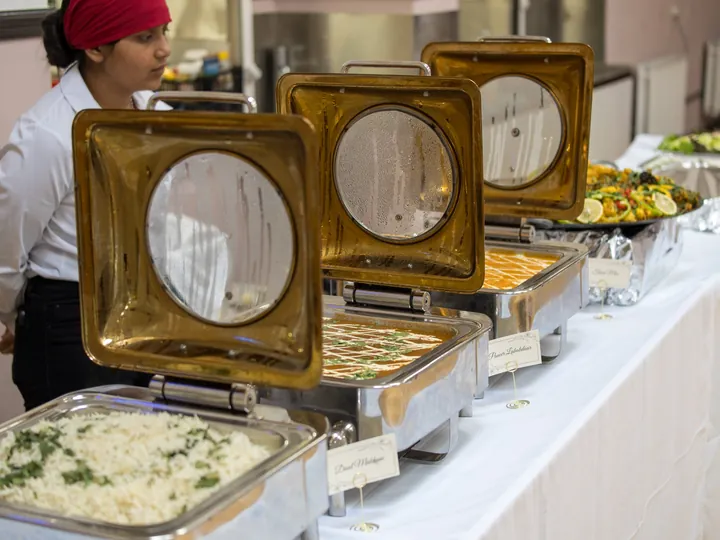 Buffet spread with labelled dishes including dal makhani and paneer lababdar