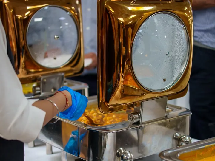 Serving hot food from a gold chafing dish
