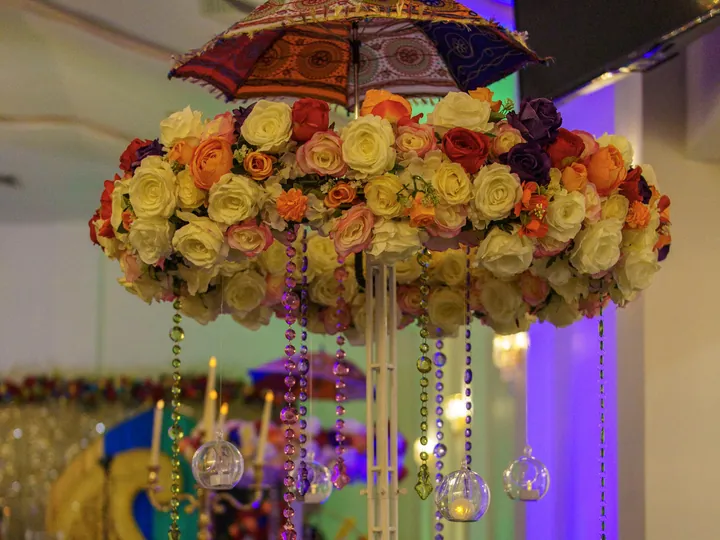 Elaborate floral centrepiece with a decorative umbrella and hanging crystals