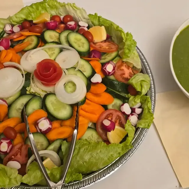 Fresh salad platter with tomato garnish and mint chutney
