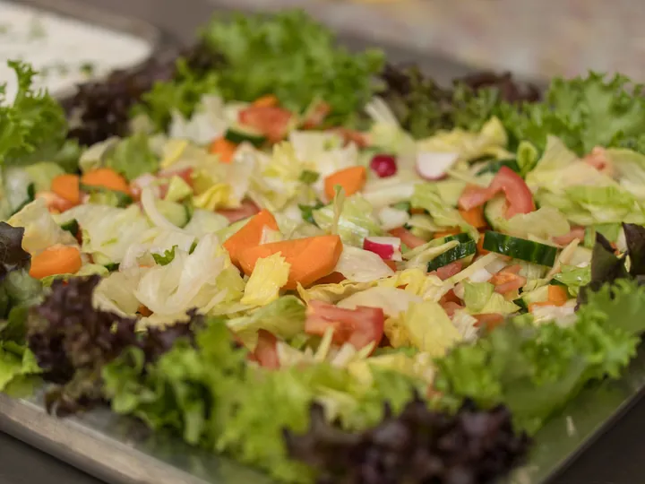 Tray of fresh salad with lettuce, tomato and carrot